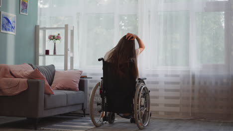 mujer discapacitada solitaria con esclerosis múltiple mira por la ventana