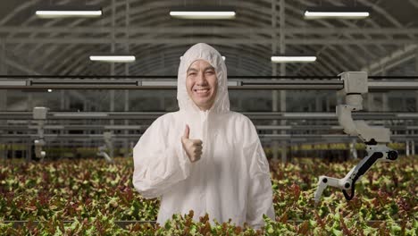 smiling worker in protective gear in a modern automated hydroponic farm