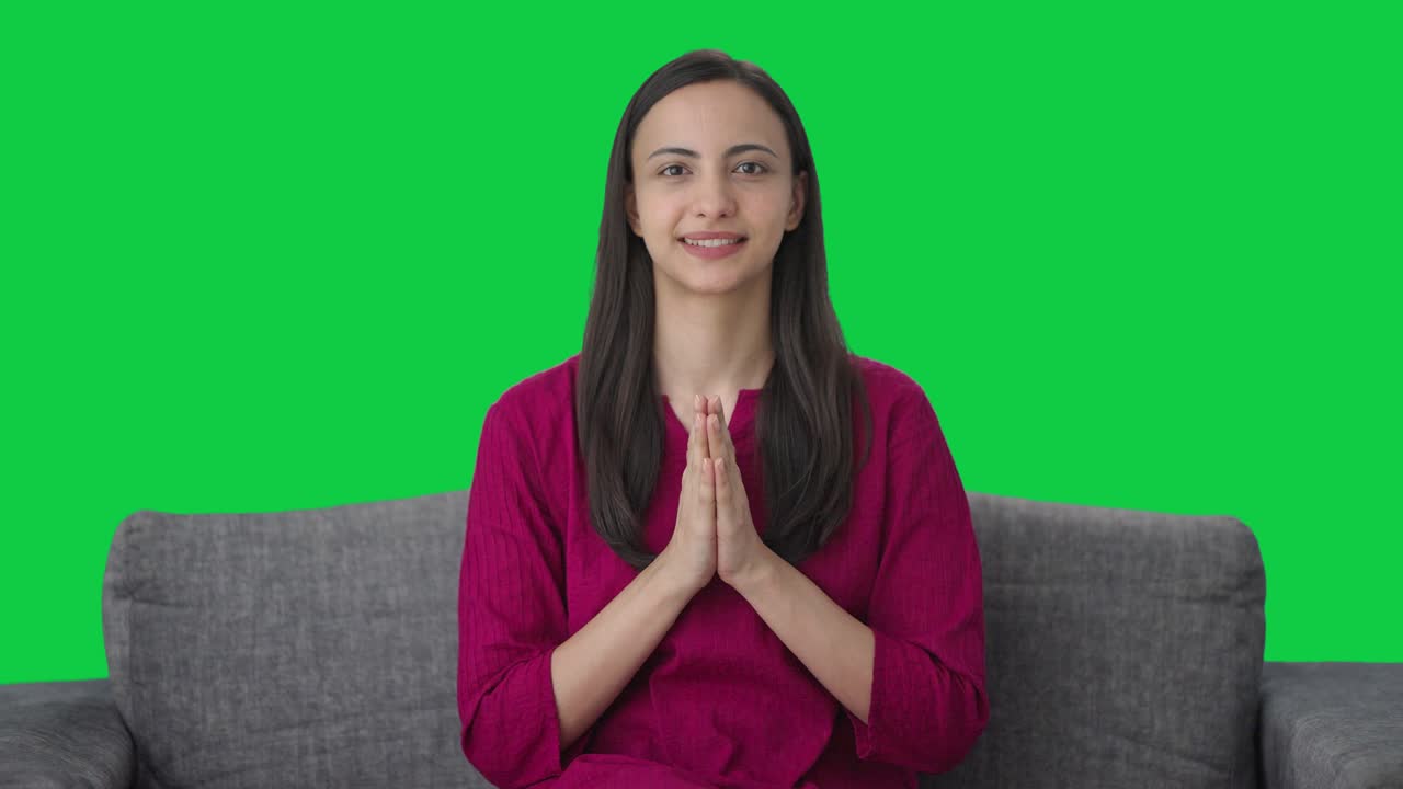 Happy Indian woman waving doing Namaste Green screen