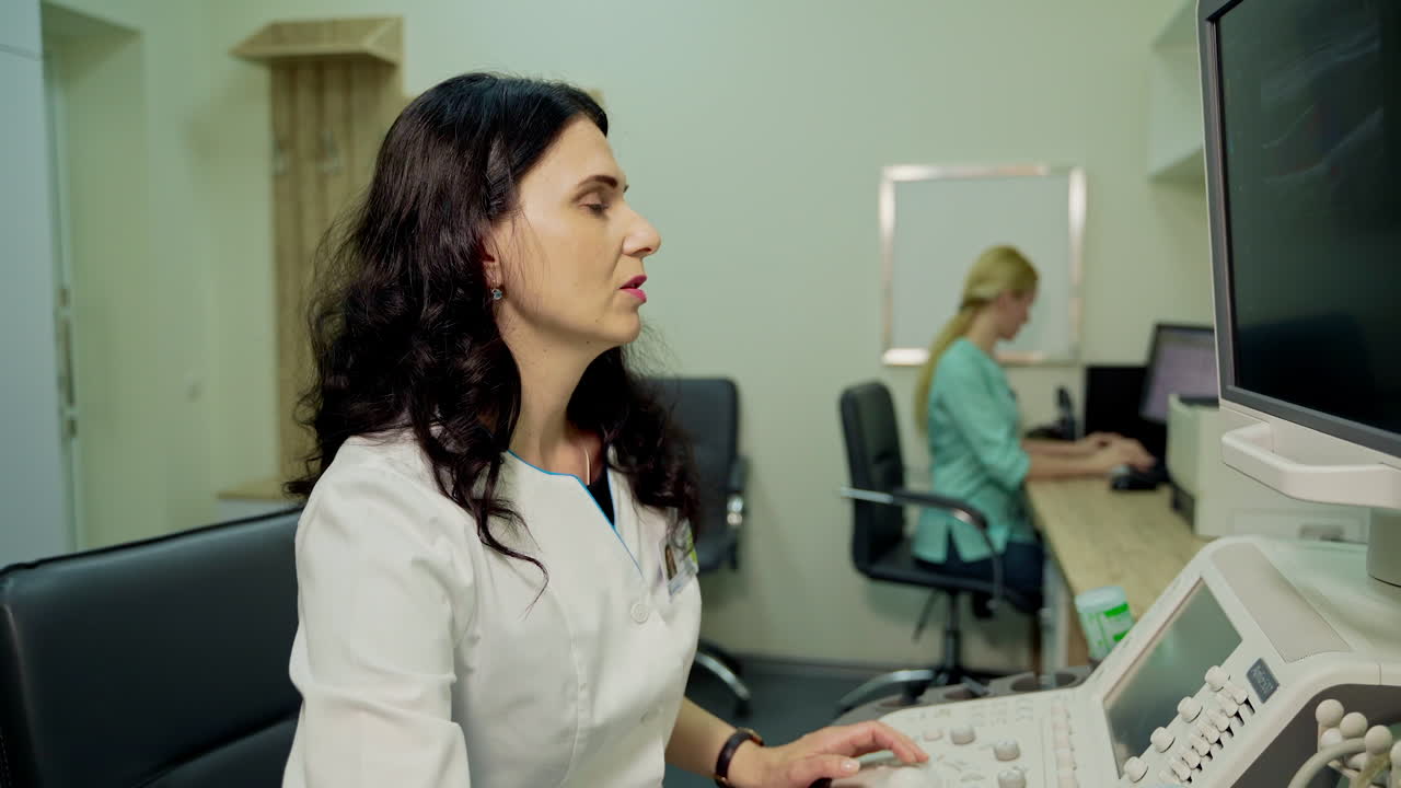 Medical specialist works with ultrasound apparatus. Professional woman doctor explaining results while doing ultrasound research in clinic.