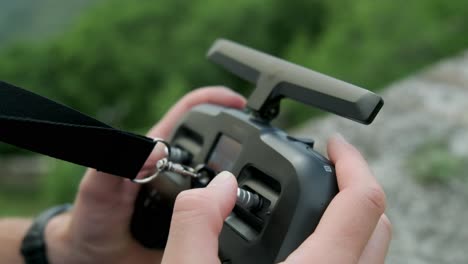 close shots of a person flying an fpv drone with his fpv remote