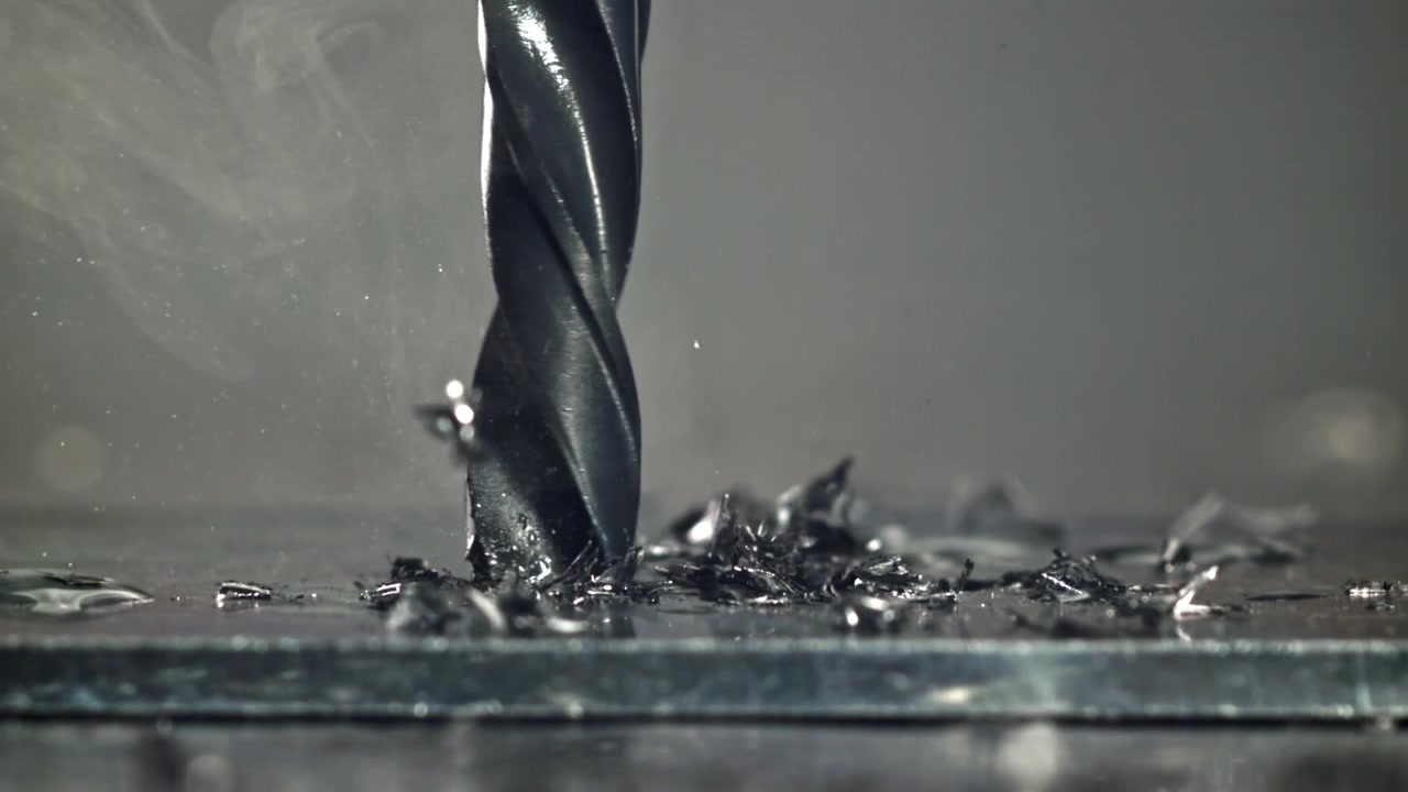 Slow Motion Close-up of Drill Bit Drilling into Metal