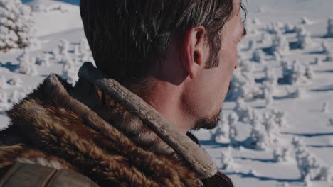 man in fur coat on a snowy mountain