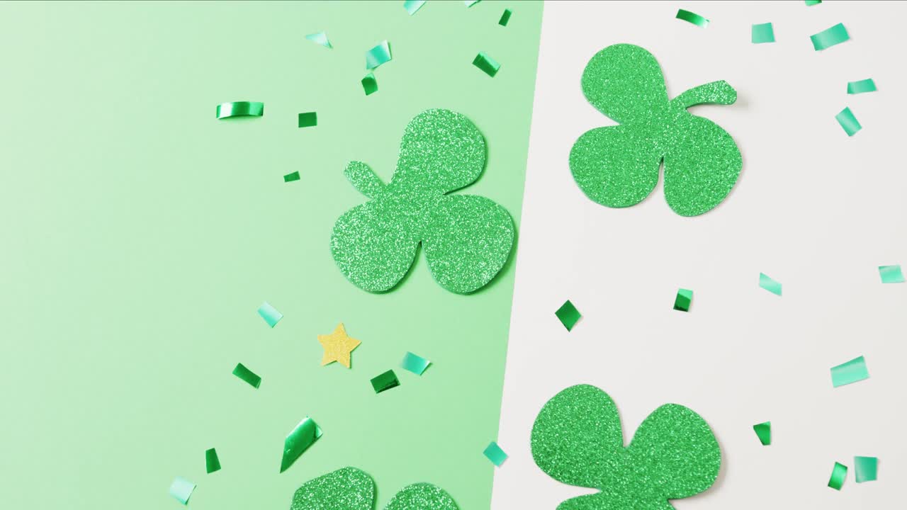 Video of st patrick's green shamrock leaves with copy space on green to white background