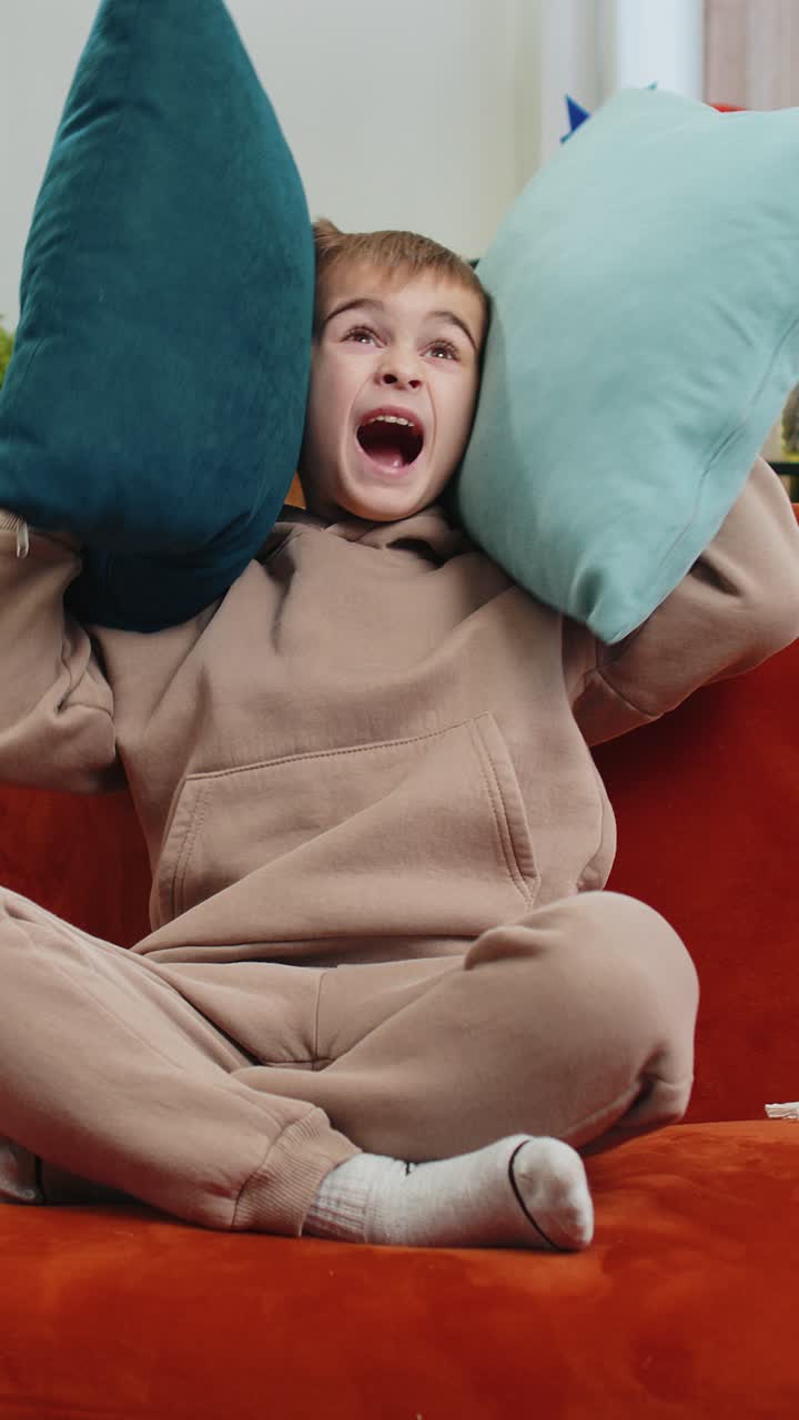 Neighbors repair work irritated boy by loud music at home cover ears with pillows annoyed by noise