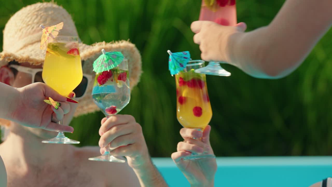 Amici che brindano con cocktail a bordo piscina