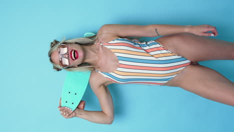 woman in striped swimsuit with skateboard