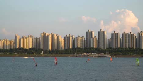 coreanos practicando windsurf en el río han en la colorida puesta de sol rosa en un complejo apartamento de rascacielos, club de surf ttukseom, estática diurna