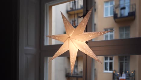 glowing paper star christmas decoration in window