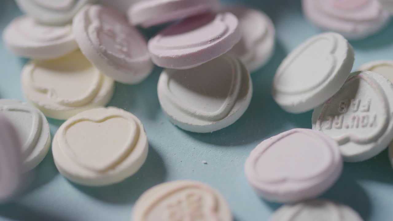 파란색 배경에 던져진 낭만적인 사랑의 메시지가 담긴 하트 캔디 1