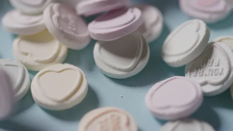 dulces de corazón con mensajes románticos de amor arrojados sobre fondo azul 1