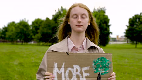 close up of a redhead woman holding a placard