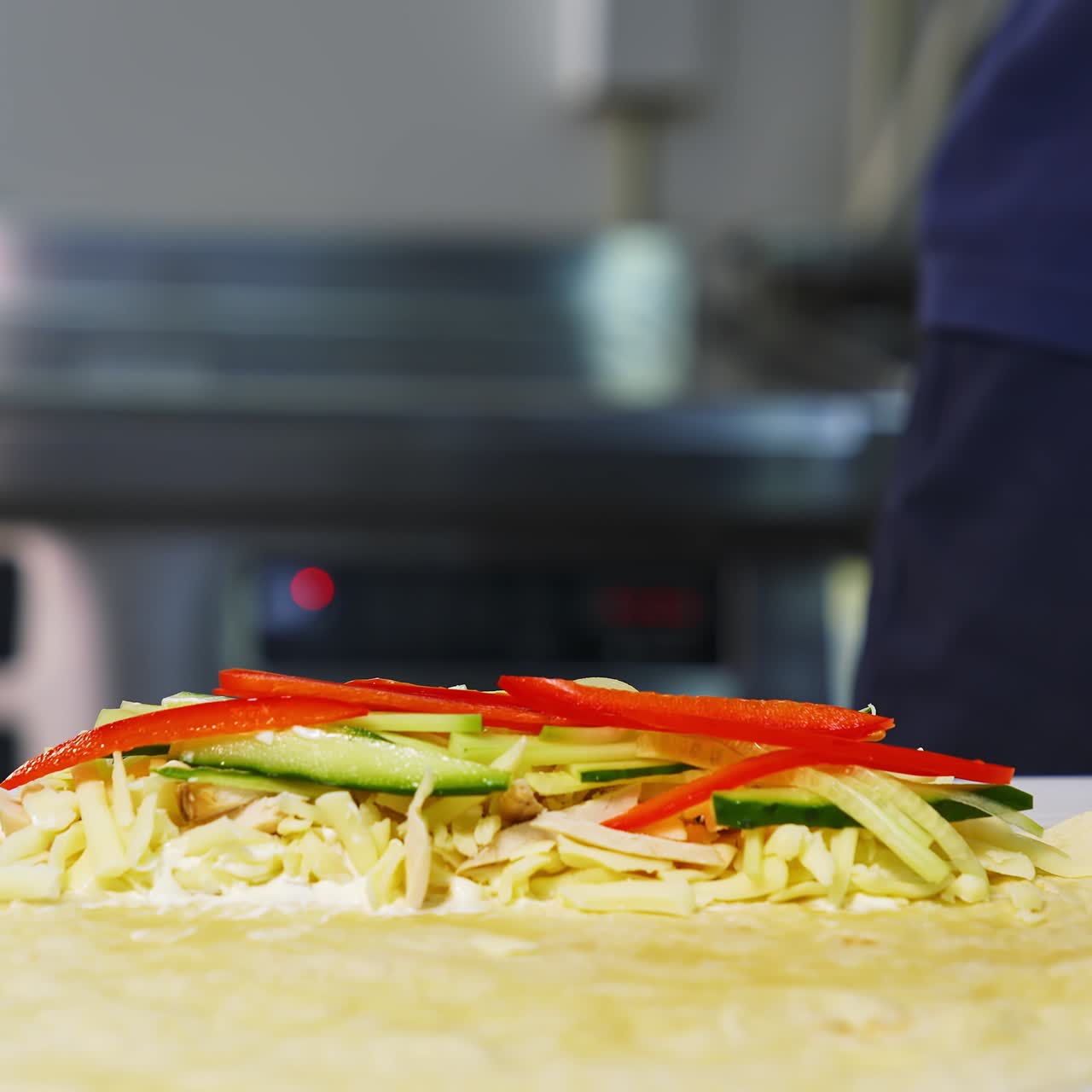 Cooking meal in fast food restaurant. Professional cook in white gloves puts filling with cutted vegetables into pita. Process of cooking tasty snack