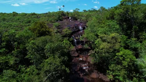 el río de siete colores caño cristales, que es atravesado por un largo puente blanco que conecta las dos orillas de la reserva natural, río colombiano ubicado en la sierra de la macarena