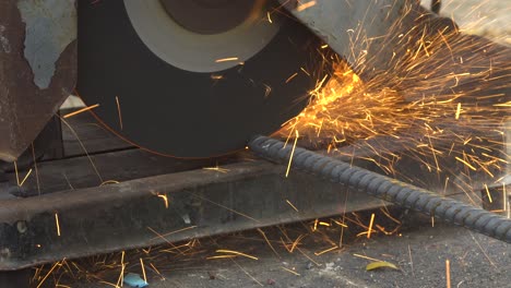 trabajador que corta una línea de metal con una sierra circular