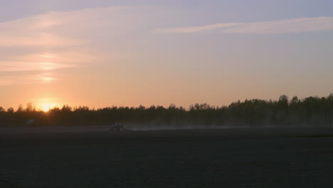 tractor working in the field at sunset