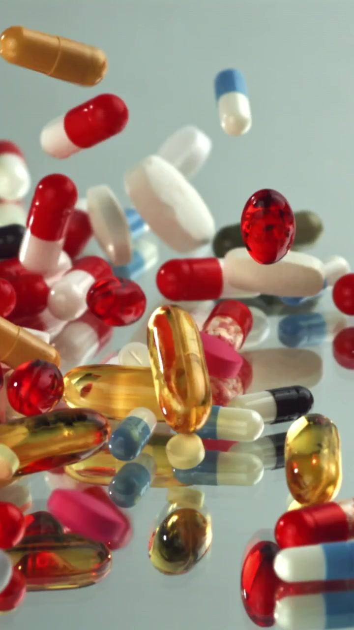 Colorful Pills and Capsules Falling in Slow Motion