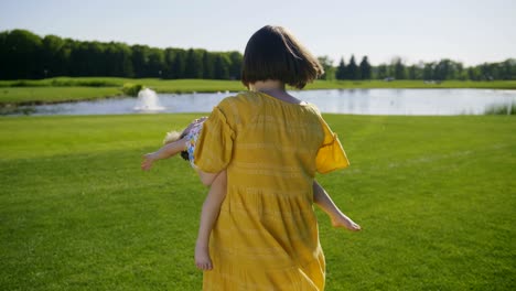 joyful mother spinning speial needs girl in park