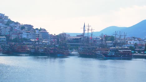 ships and boats docked at seaport in alanya , calm sunny summer day, handheld medium shot, seaside view