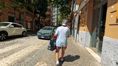 a man strolls through a sunny naples street