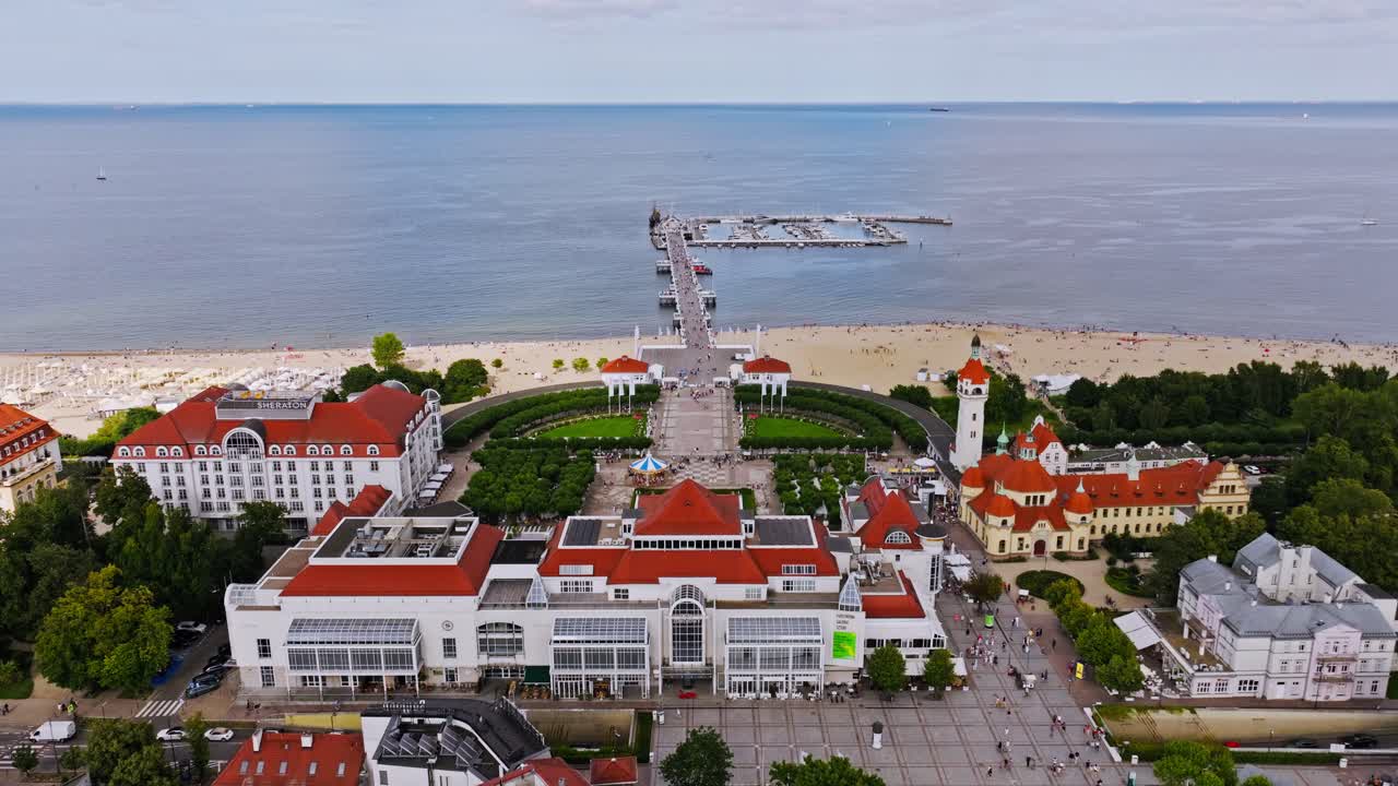 Right slide drone shot of Sopot seaside complex with pier and sandy beach