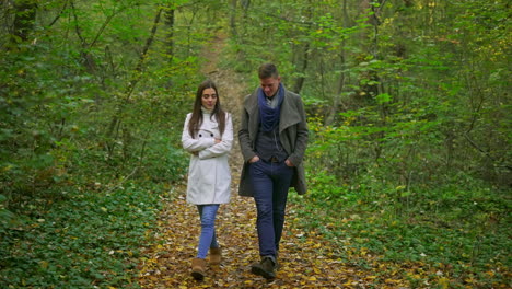 a couple walking in the forest during autumn