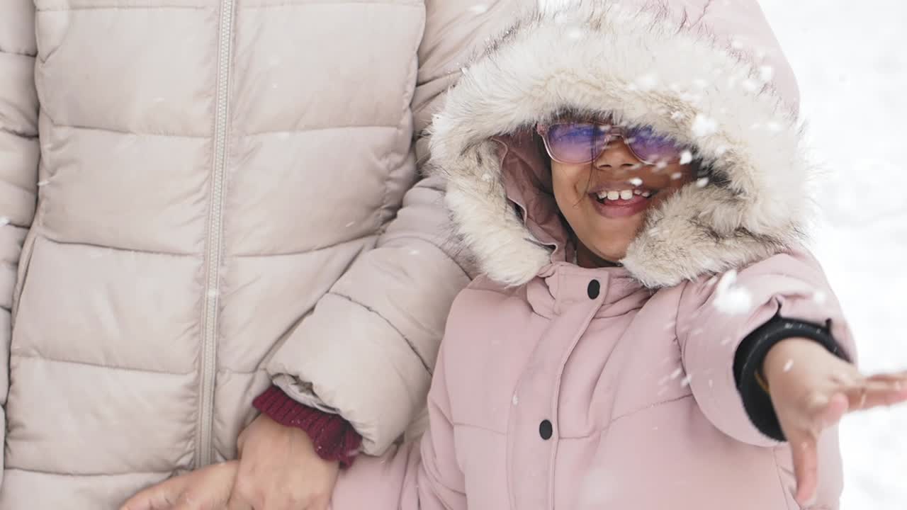 A child and mother enjoying a snowy winter day