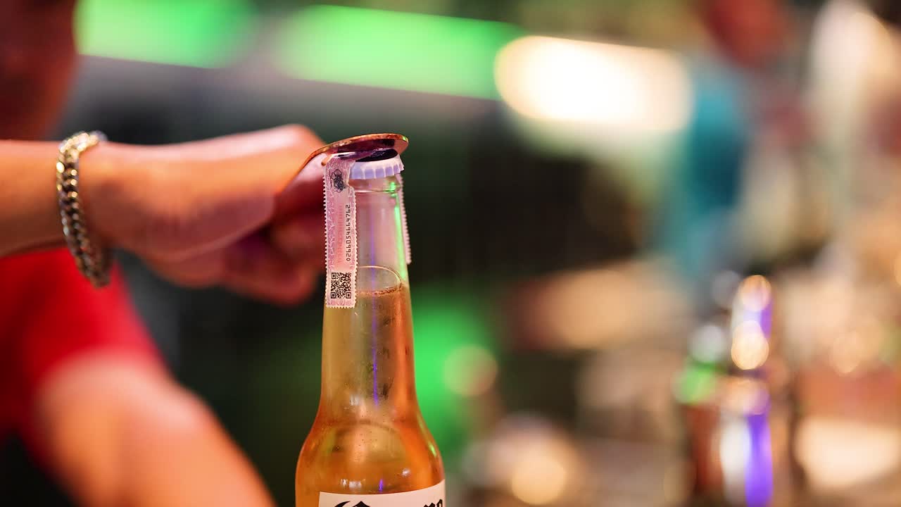 persona abriendo una botella con una herramienta