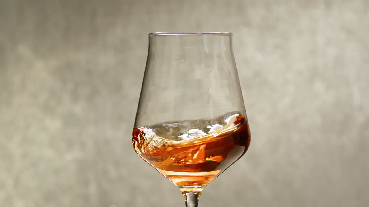 Rose Orange or white wine bottle and glass against a sunset in a peaceful vineyard, pouring of ecological natural wine. Cheers, hands with wine glasses, drinking alcohol.