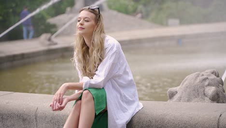 woman relaxing by a fountain