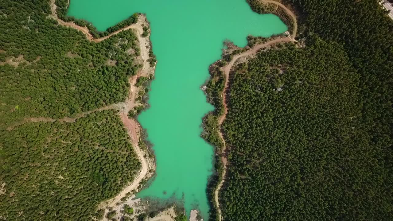 agua turquesa en un lago de bosque de montaña con pinos