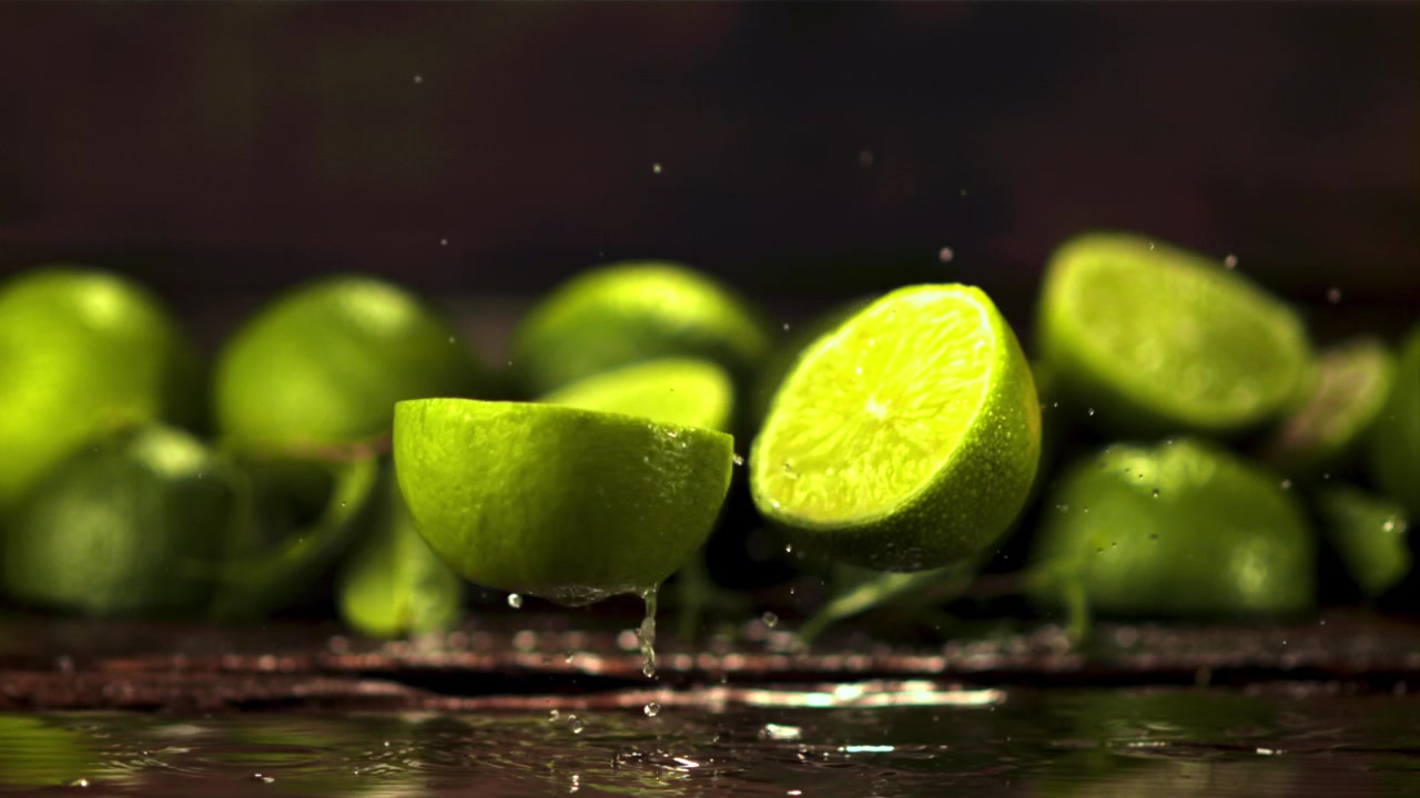Super slowmotion af en frisk lime, der falder og deler sig i to halvdele