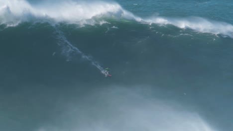 big wave surfer carlos burle riding a monster wave in nazaré, portugal