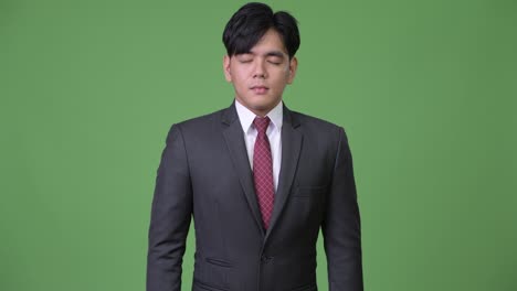 young handsome asian businessman relaxing with eyes closed