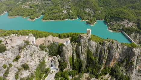 aerial view of a cliffside village and turquoise lake in spain