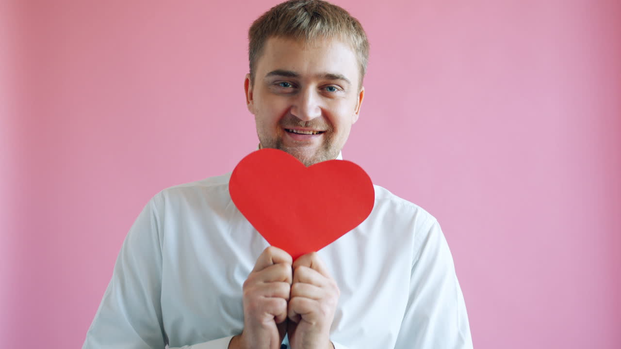 hombre sosteniendo un corazon rojo