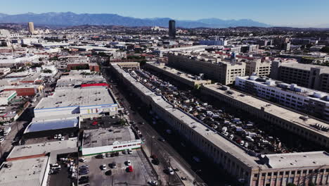 aerial view of a bustling city with a large market and mountains in the background