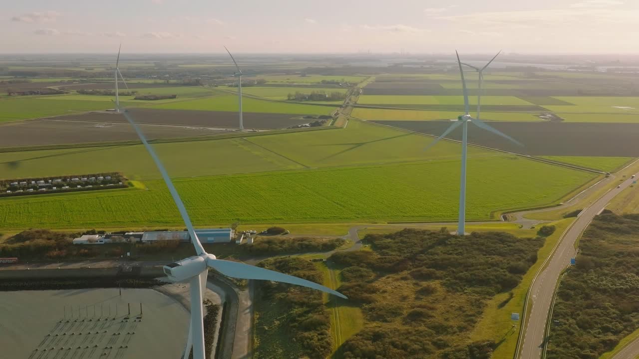 замедленная съемка ветряных турбин и движения на дороге в сельской местности нидерландов в прекрасный солнечный день на закате солнца