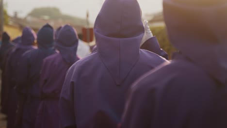 easter sunday of holy week celebration with men in purple hooded robes in antigua, guatemala