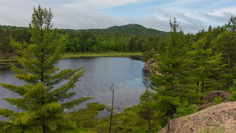 motion time-lapse of clouds and fog swirling over a pond in the forests of northern michigan