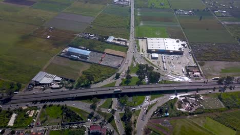 Una-Vista-Aérea-De-Un-Intercambio-De-Hojas-De-Trébol-En-Una-Pequeña-Carretera-En-Chalco-México