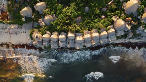 Rising-shot-shows-the-beach-huts-on-the-seafront-at-the-Azulik-resort,-Mexico