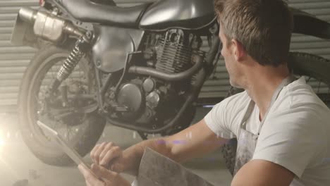 animation of glowing lights over caucasian male mechanic repairing motorbike in garage