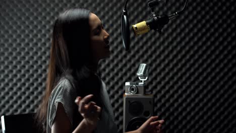 Asiatische-Teenager-Frau,-Die-Schwarzes-Langes-Haar-Umwickelt,-Singt-Laut-Ein-Lied-Mit-Power-Sound-über-Hängendem-Mikrofon-Kondensator-Und-Ausrüstung
