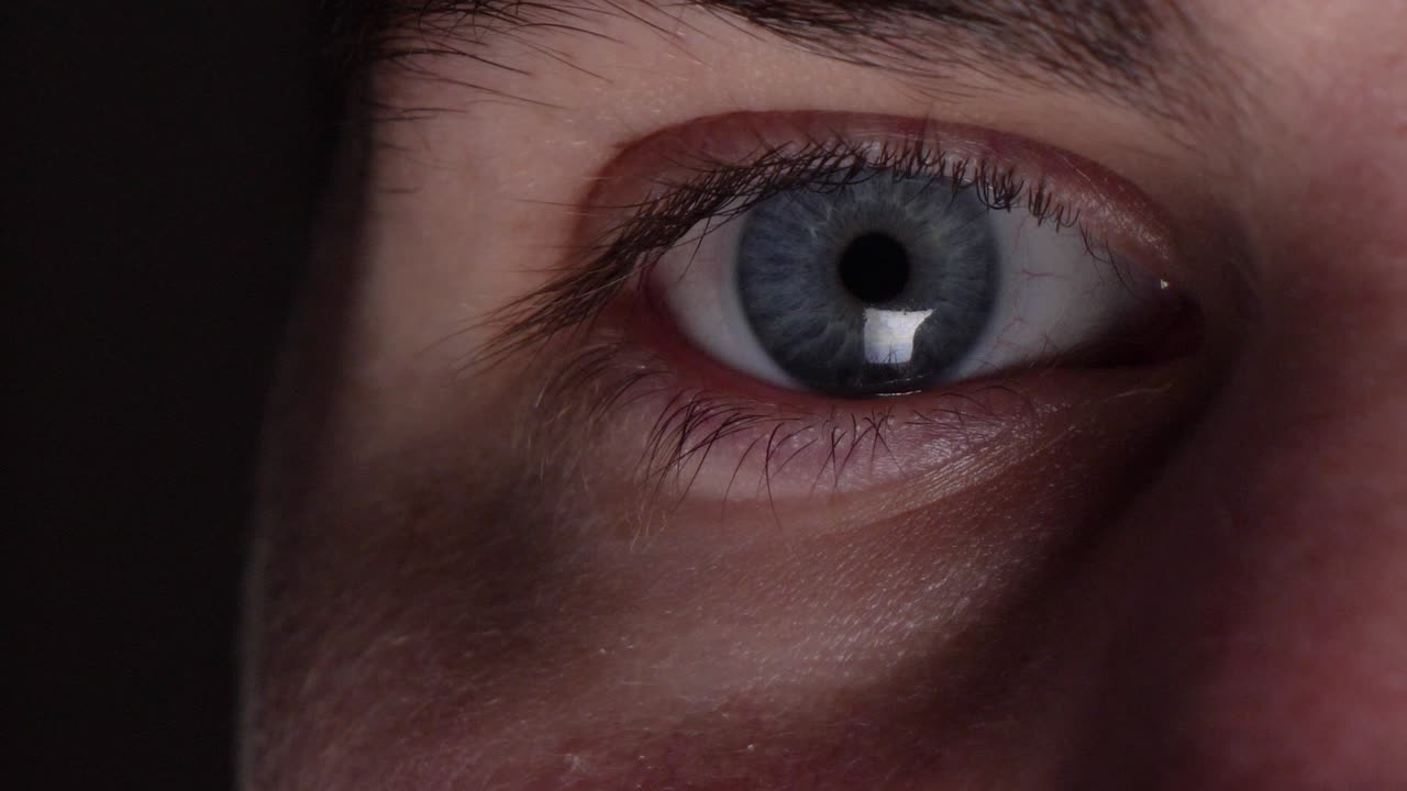 primer plano del ojo masculino con reflejo de la pantalla de la computadora en el globo ocular