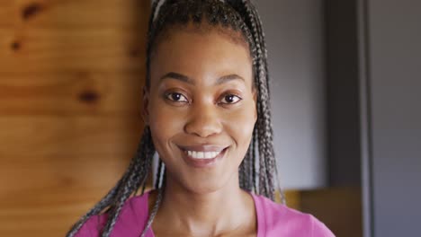 portrait of happy african american woman looking at camera and smiling in log cabin, slow motion