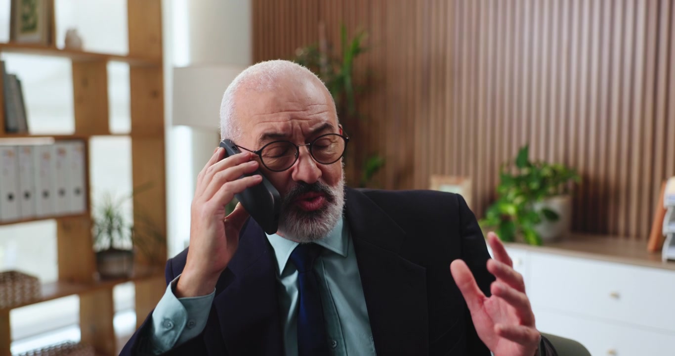 Senior Businessman Talking on Smartphone in Modern Office