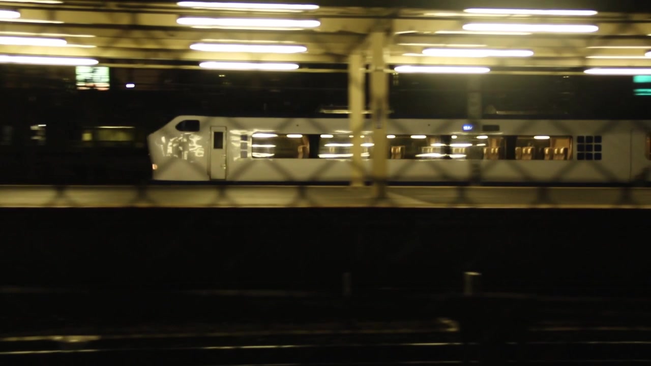 Un treno veloce arriva in stazione ferroviaria di notte.