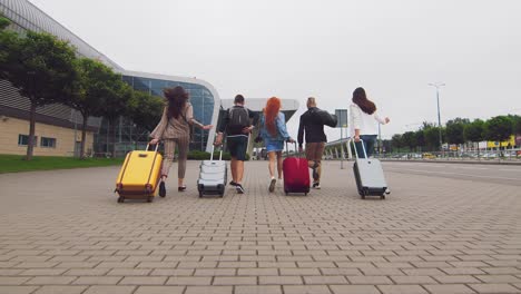 tourists travelers run to the airport terminal. flight delay. young people run with luggage to the airport terminal.