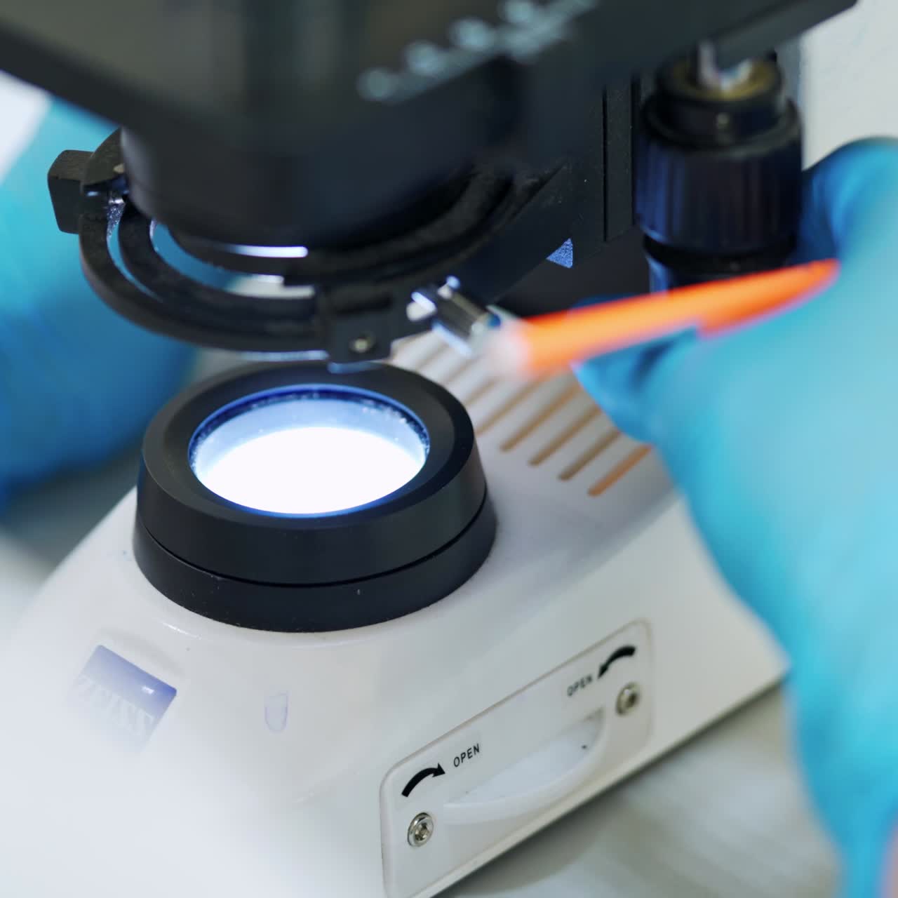 Chemist examining blood with microscope